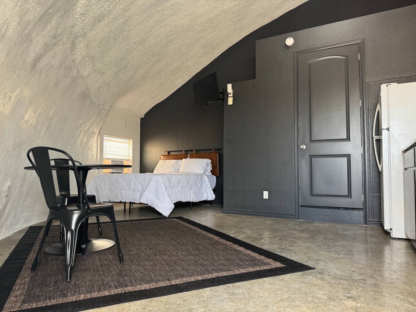 Queen bed and seating area inside a dome room at The Domain, Aransas Pass
