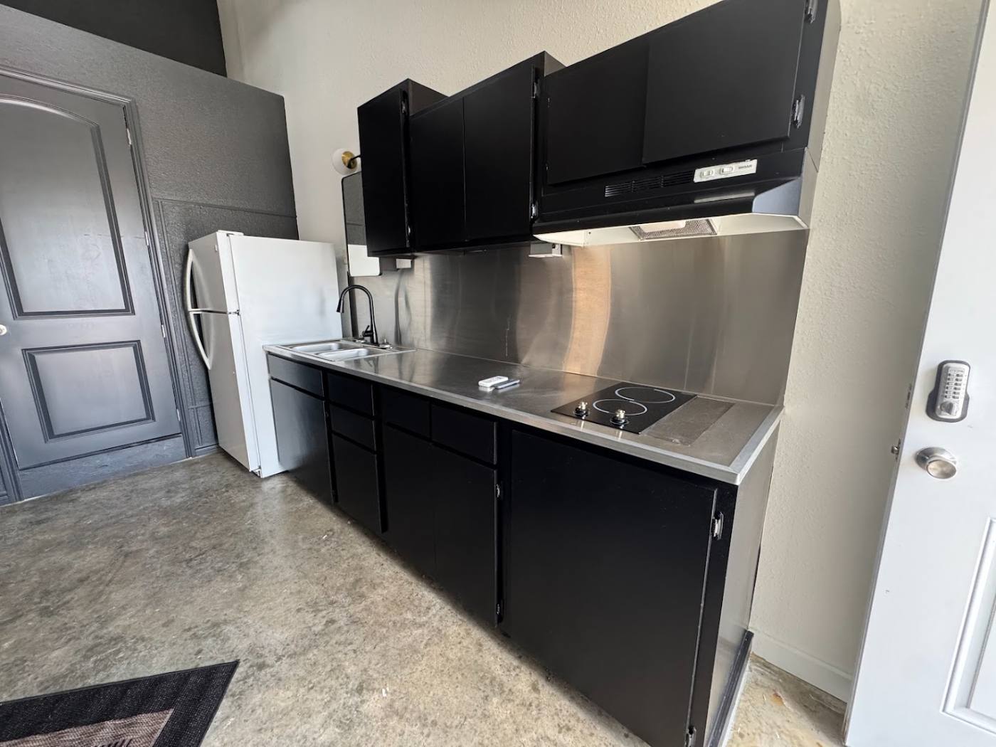 Kitchenette with stainless counter, cooktop and refrigerator in a dome at The Domain