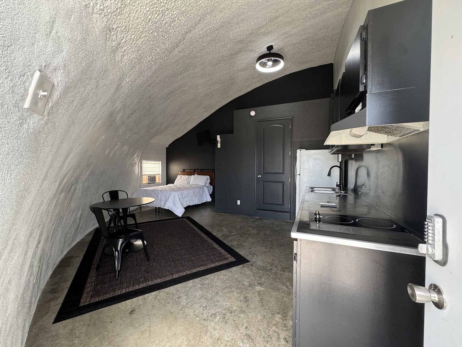 Premium dome interior with bed and full kitchenette at The Domain