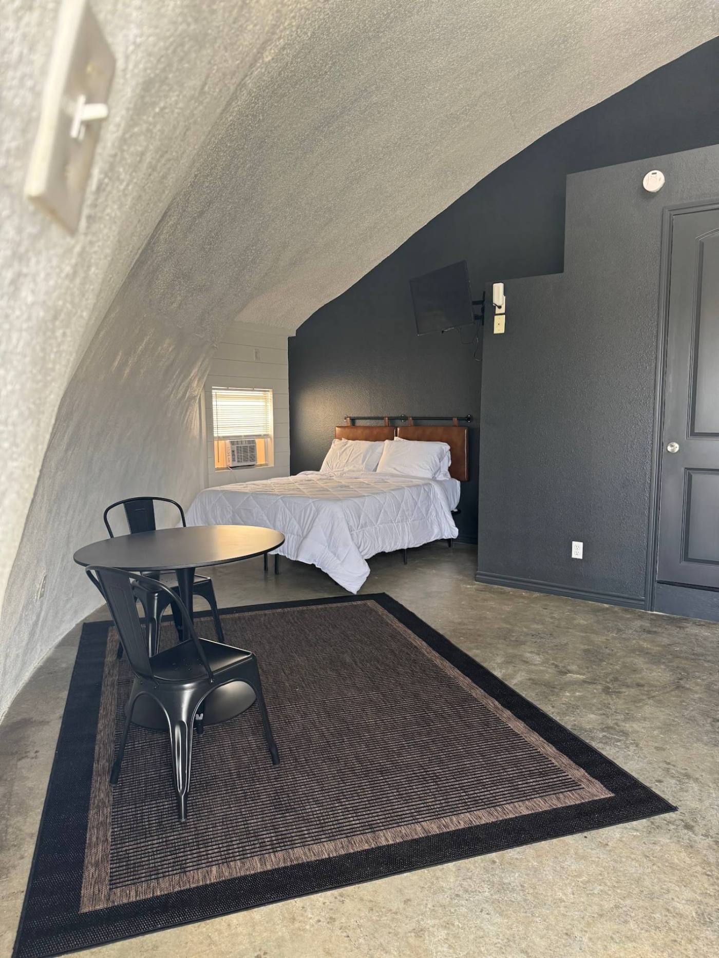 Table and chairs beside the bed in a dome room at The Domain